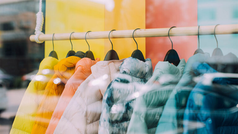 Clothing store window display with colorful winter jackets.