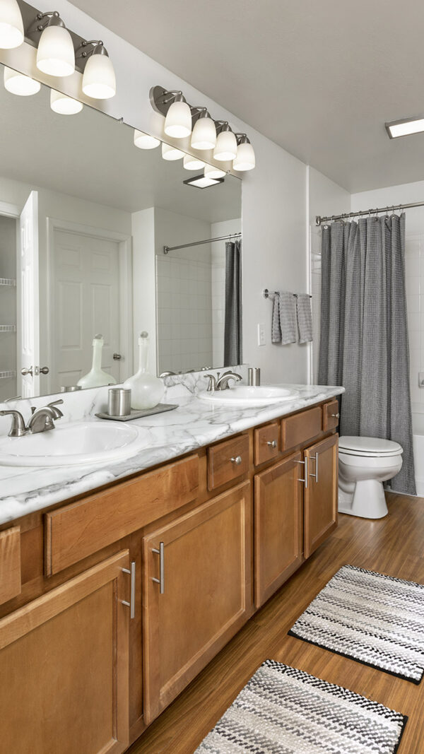 Apartment Bathroom with large soaking tub, Double Sink and hardwood flooring.