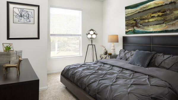 Spacious apartment bedroom with carpeted floors.