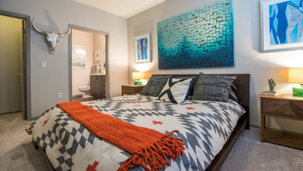 Spacious apartment bedroom with carpeted floors overlooking bathroom.