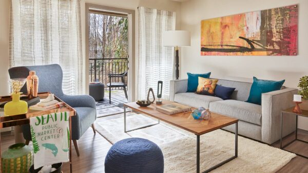 Apartment living room with wood-style flooring and patio or balcony in select homes.