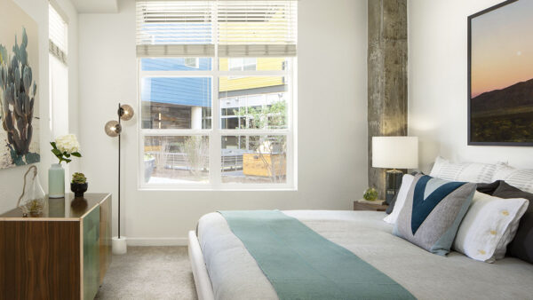 Spacious apartment bedroom with carpeted floors.