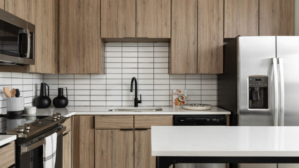 Apartment Kitchen with Stainless Steel Appliances, quartz counters and wood floors.