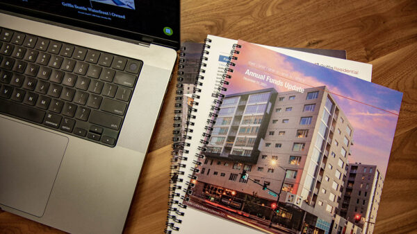 Desk with laptop computer and Griffis investor pamphlets.