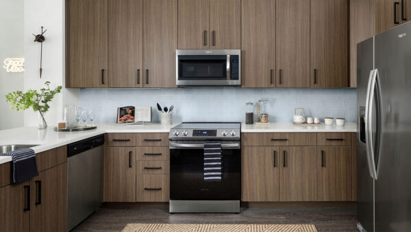 Apartment Kitchen with Stainless Steel Appliances, quartz countertop and hardwood flooring.