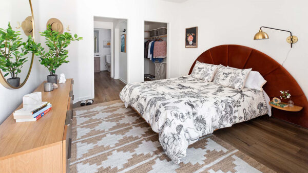 Spacious apartment bedroom with large closet and wood-style flooring.