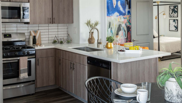 Apartment Kitchen with Stainless Steel Appliances, quartz counters and wood floors.