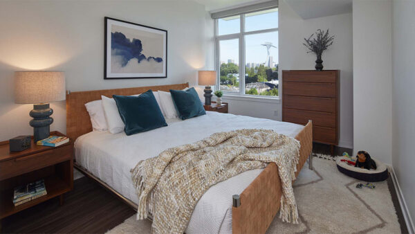 Spacious apartment bedroom with wood-style flooring.