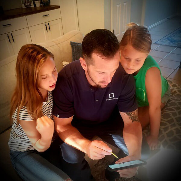 Griffis Residential employee working on smart phone with children.