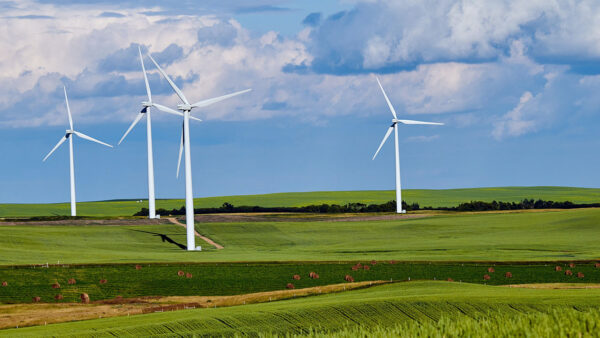 Large wind turbines towering over farm fields.