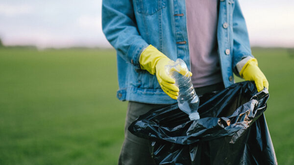Person picking up trash outside.