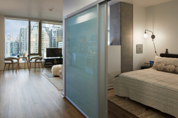 Spacious apartment bedroom with wood-style flooring.