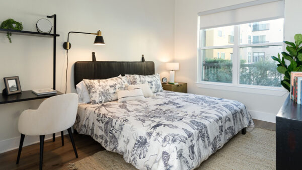 Spacious apartment bedroom with wood-style flooring.