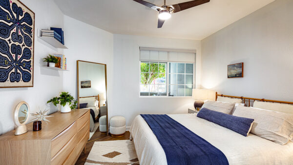 Spacious apartment bedroom with wood-style flooring.