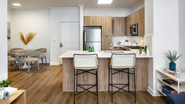 Gourmet kitchen and dining area with stainless steel appliances, quartz countertops and wood-style flooring.