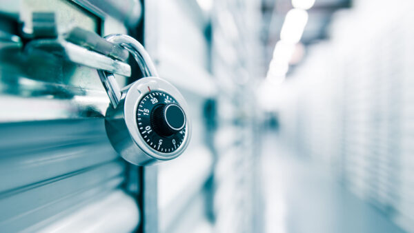 Metal padlock on secure storage locker door inside storage facility.
