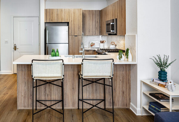 A kitchen with a breakfast bar and a view of the adjacent dining area with a round table.