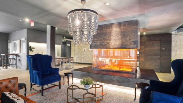 Entertainment lounge with fireplace, plush seating, and elegant chandelier.