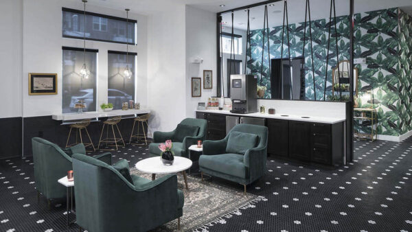 Hospitality area with coffee machine, floral tile floors, and plush seating.