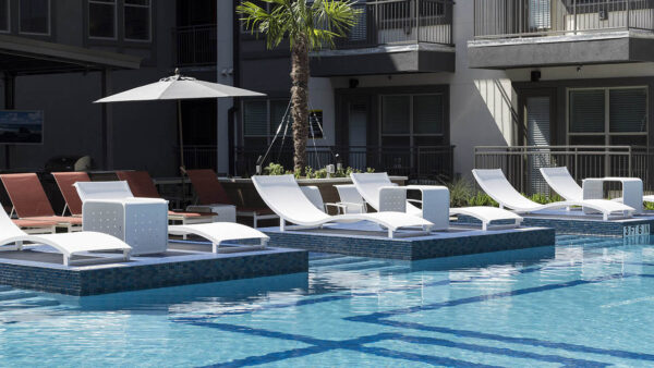 Resort-style pool with lounge chairs and gazebos.