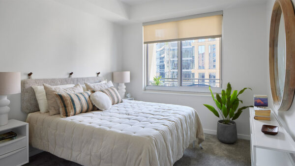 Spacious apartment bedroom with polished concrete flooring.