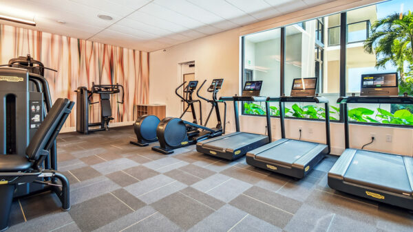 Griffis West Palm apartments fitness center with cardio machines and weight equipment.