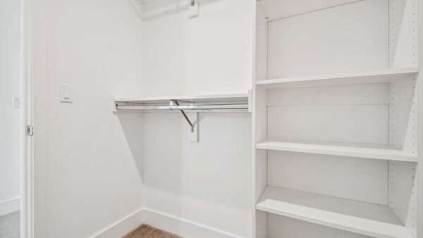 Griffis West Palm apartment closet with built in shelves and clothes rods.