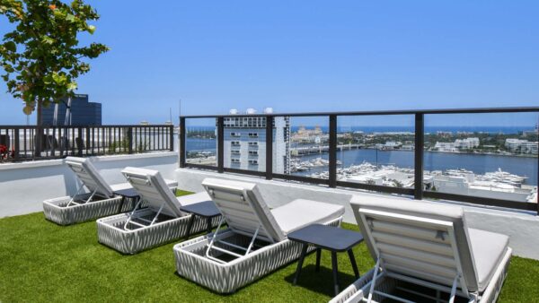 Griffis West Palm apartments rooftop deck with turf lawn and lounge chairs overlooking West Palm Beach.
