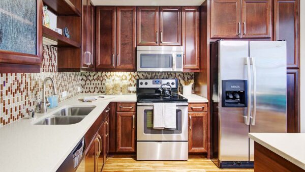 Griffis Uptown apartment kitchen with quartz countertops and stainless steel appliances.