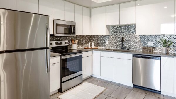 Griffis Pompano Beach apartment kitchen with quartz countertops and stainless steel appliances.