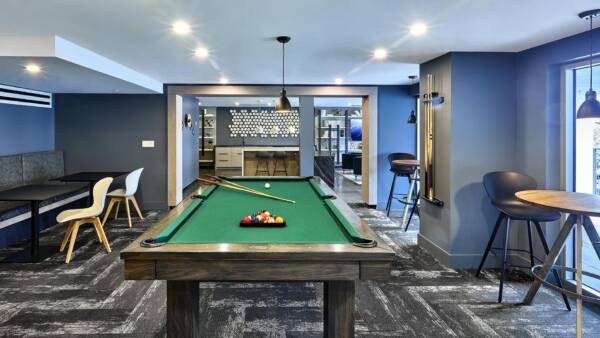 Apartment community room with pool table and seating.